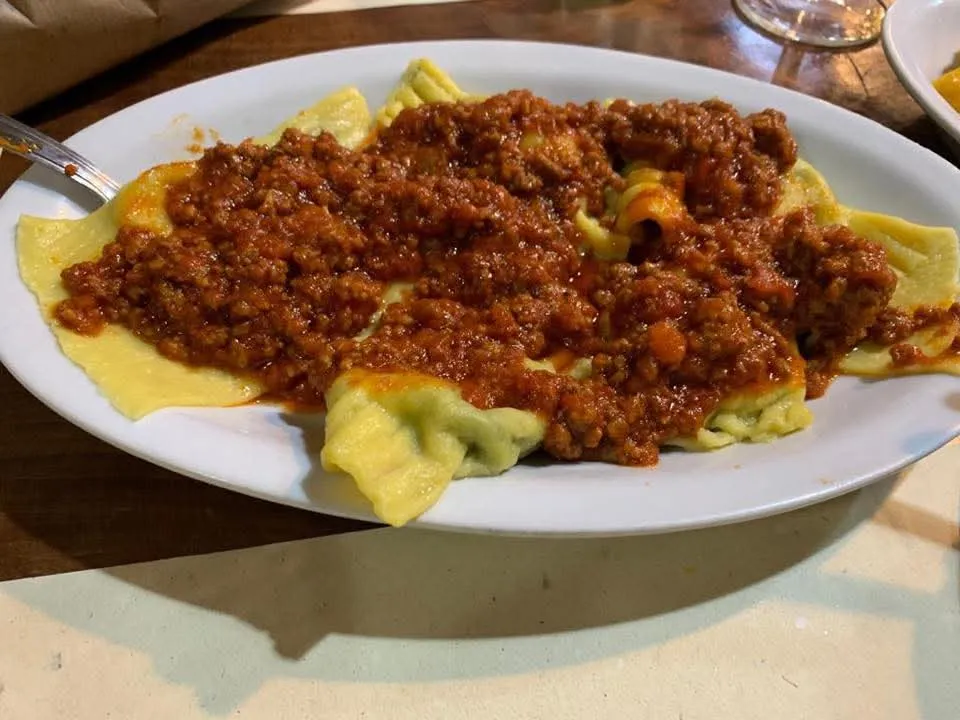 Un piatto di ravioli fatti a mano, conditi con il ragù di carne.